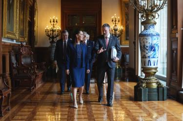 Claudia Sheinbaum y Jamieson Greer conversan caminando en un pasillo ornamentado del Palacio Nacional tras concluir la reunión del T-MEC.