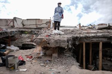 Un rescatista con equipo de protección trabaja entre los escombros de un edificio colapsado tras el terremoto en Cali, Colombia.