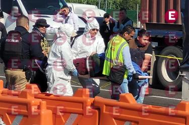 Peritos forenses y elementos de la Fiscalía trasladando un cuerpo en una camilla tras un incidente de seguridad.
