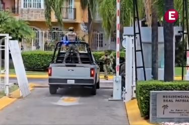 Camioneta de seguridad de la Marina mexicana con personal armado ingresando a la entrada del Residencial Real Patria en Tlaquepaque, Jalisco. Incluye cartel con dirección visible.