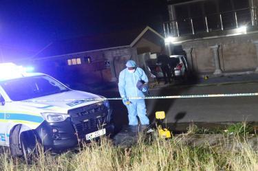 Personal del servicio forense trabaja en la zona donde fue asesinado el excampeón mundial Zolani Tete, en Mdantsane, Sudáfrica.