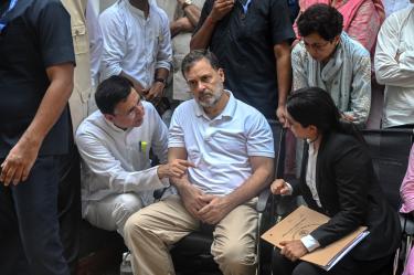 Rahul Gandhi permanece sentado junto a miembros del Partido del Congreso durante una protesta en una comisaría de Nueva Delhi.