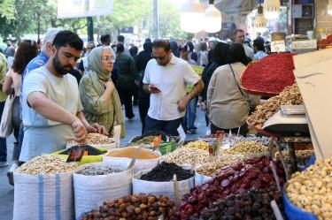 Un comerciante coloca frutos secos y nueces frente a su tienda en un mercado de Teherán