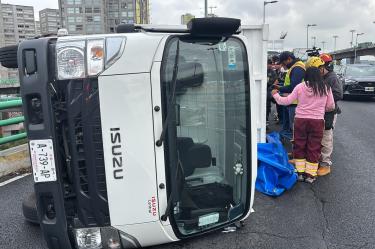 Camioneta blanca de redillas volcada sobre su costado izquierdo en el Segundo Piso del Periférico de la CDMX, con cuerpos de emergencia laborando en el lugar.