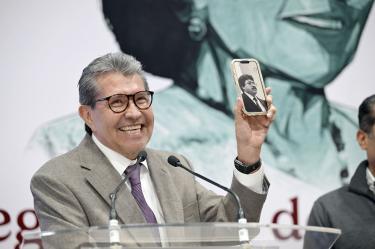 Ricardo Monreal participa en una conferencia de prensa y muestra un teléfono celular durante sus declaraciones sobre la agenda legislativa.