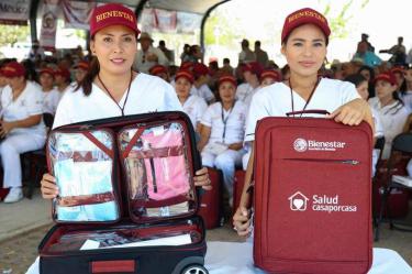 Dos integrantes de Salud Casa por Casa muestran maletas con equipo médico durante una actividad del programa de Bienestar en México.