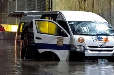 Combi de transporte público de la Ruta 30 atrapada en una severa inundación nocturna en Tultitlán, Estado de México.