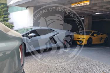 Dos automóviles deportivos Lamborghini, uno gris y uno amarillo, asegurados en un estacionamiento subterráneo por presunto lavado de dinero.