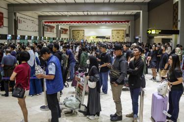 Pasajeros esperan con equipaje en el aeropuerto de Yakarta tras las interrupciones de vuelos por la ceniza volcánica del Anak Krakatoa.