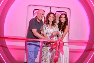 Tres personas inauguran Stella Rosa Summer Experience frente a un escenario rosa, durante el corte de listón en Ciudad de México.