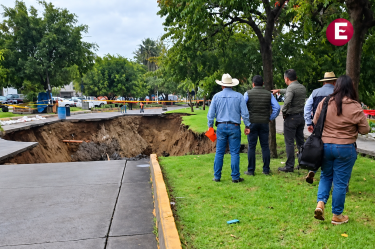 Autoridades y civiles observan el mega socavón que colapsó parte del asfalto y áreas verdes en la avenida Malecón, Tonalá.