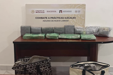 Paquetes asegurados son exhibidos sobre una mesa en la Aduana de Nuevo Laredo, Tamaulipas, durante un operativo de autoridades.
