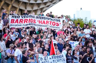 Manifestantes en Sevilla sostienen pancartas por el derecho a la vivienda digna durante una concentración en homenaje a Maricarmen Abascal.