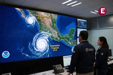 Especialistas del Servicio Meteorológico Nacional monitoreando en una pantalla gigante la trayectoria del huracán Simón y la depresión tropical 21-E en las costas de México.