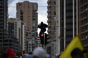 Manifestantes participan en una movilización en Colombia y portan pancartas, banderas y consignas de rechazo a las políticas del Gobierno.