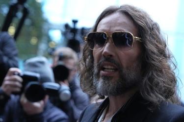 British comedian and actor Russell Brand arrives at Southwark Crown Court in south London on October 14, 2026, for the start of his trial. 51-year-old Brand faces seven sexual offence charges involving six women, relating to a period between 1999 and 2009. (Photo by Ben Stansall / AFP)