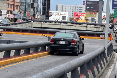 Vehículo negro tipo Vento con impactos de bala en el vidrio trasero, detenido sobre el puente de Gómez Morín y Morones Prieto tras ataque armado.