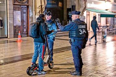 Transeúnte francés detenido por policías al aplicar toque de queda.