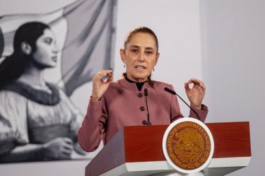 La presidenta Claudia Sheinbaum hablando desde el atril con el Escudo Nacional durante su conferencia matutina.
