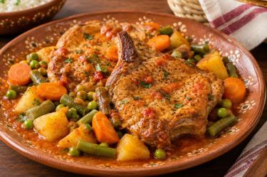 Combina lo jugoso de las chuletas de cerdo con verduras para una comida completa y saludable