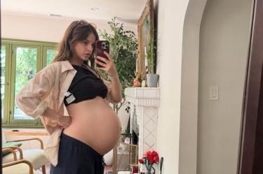 Barbara Palvin embarazada muestra su vientre frente a un espejo mientras se toma una selfie con su celular en casa.
