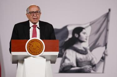 El secretario de Salud, David Kershenobich, hablando desde un atril con el escudo de México durante una conferencia gubernamental.