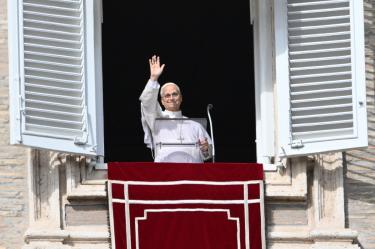 El papa León XIV saluda a la multitud desde la ventana del palacio apostólico que da a la plaza de San Pedro