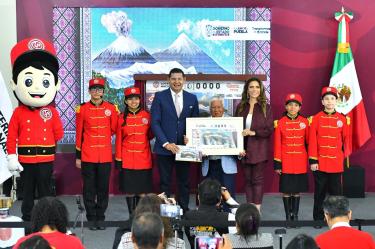 El gobernador Alejandro Armenta y la titular de la Lotería, Olivia Salomón, develan billete inspirado en Puebla y sus majestuosas montañas