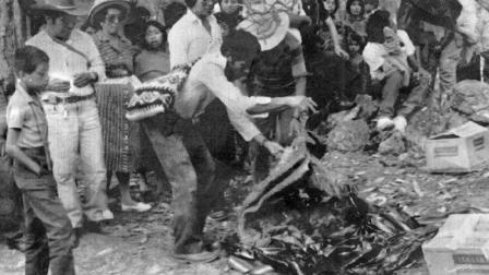 Un hombre levanta una manta que cubre los restos encontrados en la Ciudad de Guatemala, de presuntas víctimas de una matanza perpetrada en 1982.