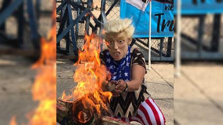 Frente a la embajada de EU en México, un manifestante quemando una piñata con una foto de Donald Trump. 