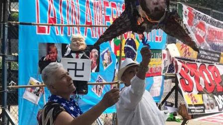 Frente a la embajada de EU en México, un manifestante quemando una piñata con una foto de Donald Trump.