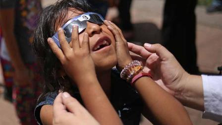 Una niña observa el eclipse solar hoy, lunes 21 de agosto de 2017, en el atrio de la Iglesia de La Mercen en Antigua (Guatemala).