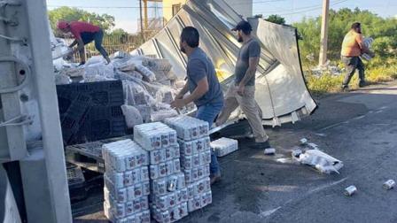 Una hora fue suficiente para que pobladores de la ciudad de Nuevo Laredo dejaran vacío un tráiler que iba cargado con miles de botes de cerveza y que volcó sobe la carretera Nacional.