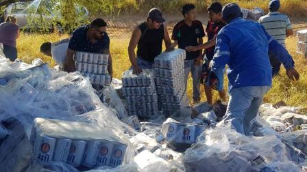 Una hora fue suficiente para que pobladores de la ciudad de Nuevo Laredo dejaran vacío un tráiler que iba cargado con miles de botes de cerveza y que volcó sobe la carretera Nacional.