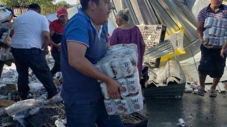 Una hora fue suficiente para que pobladores de la ciudad de Nuevo Laredo dejaran vacío un tráiler que iba cargado con miles de botes de cerveza y que volcó sobe la carretera Nacional.