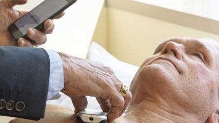 James Thomas, cardiólogo del Northwestern Hospital de Chicago, examina a Dennis Calling usando un pequeño aparato que transmite información sobre el corazón a un teléfono el 8 de julio del 2019 en Chicago. (AP Photo/Amr Alfiky)