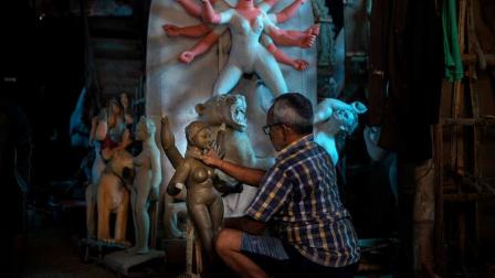 Un artesano trabaja en un ídolo de la diosa Kali antes del festival Durga Puja en Gauhati,