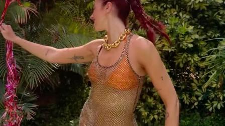 Dua Lipa con bikini naranja y blusa transparente con globos