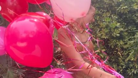 Dua Lipa con bikini naranja y blusa transparente con globos