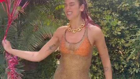 Dua Lipa con bikini naranja y blusa transparente con globos